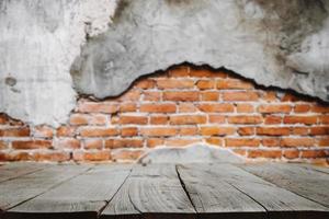 Empty dark wooden table in front  background of Old red brick wall texture photo