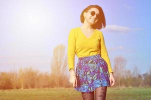 chica morena atractiva y linda en un suéter amarillo camina a través foto
