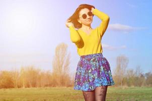 Attractive and cute Brunette girl in a yellow sweater walks thro photo