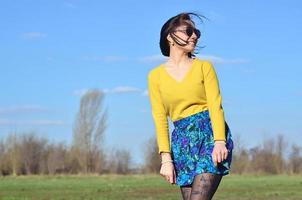 Attractive and cute Brunette girl in a yellow sweater walks thro photo