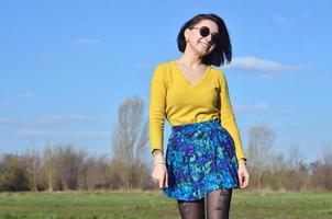 Attractive and cute Brunette girl in a yellow sweater walks thro photo