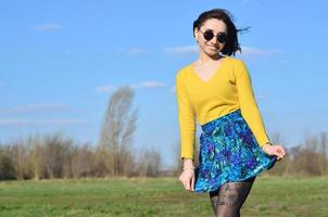 chica morena atractiva y linda en un suéter amarillo camina a través foto