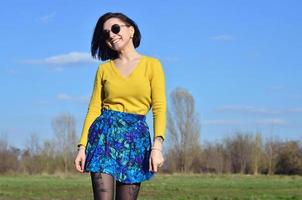 Attractive and cute Brunette girl in a yellow sweater walks thro photo