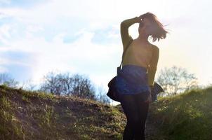 Attractive and cute Brunette girl in a yellow sweater walks thro photo