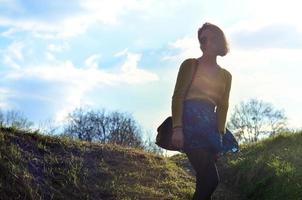 Attractive and cute Brunette girl in a yellow sweater walks thro photo