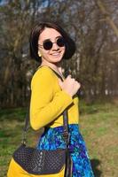 A joyful girl in a bright yellow sweater walks through the sprin photo