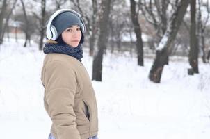 Winter portrait of young girl with headphones photo