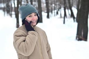 Winter portrait of young girl with smartphone photo