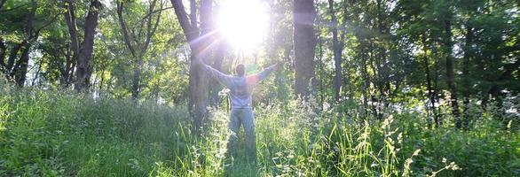 A young guy in a gray sports suit rejoices in the rising of the photo