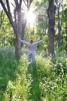 A young guy in a gray sports suit rejoices in the rising of the photo