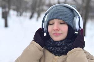 Winter portrait of young girl with headphones photo