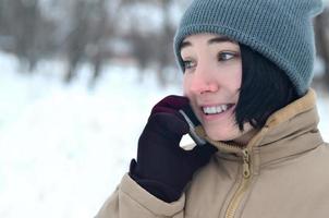 Winter portrait of young girl with smartphone photo