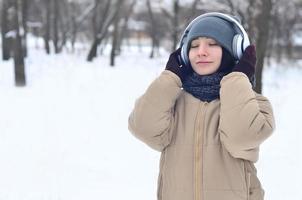 Winter portrait of young girl with headphones photo