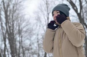 retrato de invierno de niña con teléfono inteligente foto