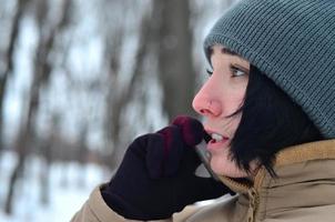 Winter portrait of young girl with smartphone photo