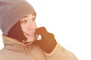 retrato de invierno de niña con teléfono inteligente foto