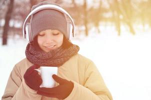 Young girl with headphones and coffee cup photo