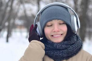 Winter portrait of young girl with headphones photo