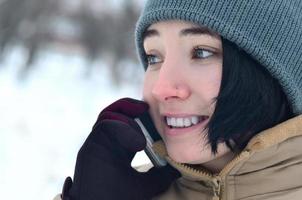 Winter portrait of young girl with smartphone photo
