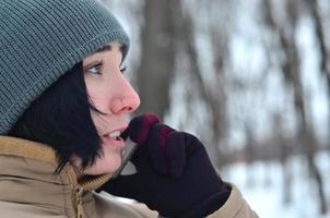 retrato de invierno de niña con teléfono inteligente foto