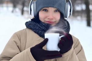 Young girl with headphones and coffee cup photo