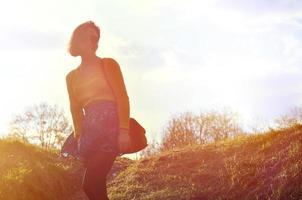 Attractive and cute Brunette girl in a yellow sweater walks thro photo