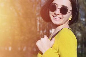 A joyful girl in a bright yellow sweater walks through the sprin photo