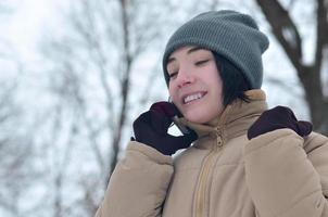 retrato de invierno de niña con teléfono inteligente foto