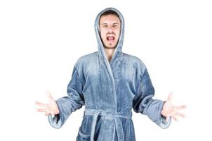 retrato de un joven caucásico con barba y albornoz azul grita de agresión aislado de fondo blanco foto