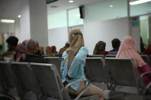 una mujer está esperando en la fila para una foto de tratamiento tomada desde atrás