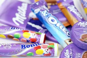 KHARKOV, UKRAINE - JULY 2, 2021 Milka chocolate products with classical lilac color wrapping design on white table photo