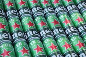 KHARKOV, UKRAINE - JULY 31, 2021 Green tin cans of Heineken lager beer produced by the Dutch brewing company Heineken N.V. photo