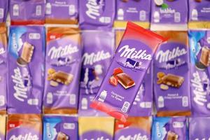 KHARKOV, UKRAINE - DECEMBER 8, 2020 Many wrappings of purple Milka chocolate. Milka is a Swiss brand of chocolate confection manufactured by company Mondelez International photo