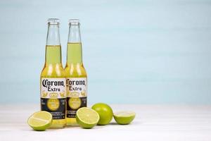 KHARKOV, UKRAINE - DECEMBER 9, 2020 Bottles of Corona Extra Beer with lime slices. Corona produced by Grupo Modelo with Anheuser Busch InBev most popular imported beer in the US photo