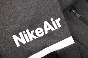 KHARKOV, UKRAINE - DECEMBER 20, 2020 Nike air logo on grey sports wear fragment. Nike is American multinational corporation engaged in manufacturing and worldwide marketing of clothes and footwear photo