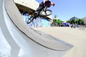 kharkiv, ucrania - 27 de mayo de 2018 ciclistas de bmx freestyle en un skatepark durante el festival anual de culturas callejeras foto