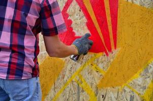 KHARKOV, UKRAINE - MAY 27, 2017 Festival of street arts. Young guys draw graffiti on portable wooden walls in the center of the city. The process of painting on walls with aerosol spray cans photo