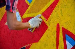 KHARKOV, UKRAINE - MAY 27, 2017 Festival of street arts. Young guys draw graffiti on portable wooden walls in the center of the city. The process of painting on walls with aerosol spray cans photo