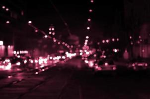 Blurred landscape of night city. Image toned in Viva Magenta, color of the 2023 year photo