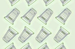 Pattern of many small shopping carts on a lime background photo