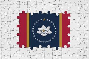 mississippi nueva bandera del estado de los estados unidos en el marco de piezas de un rompecabezas blanco con la parte central faltante foto