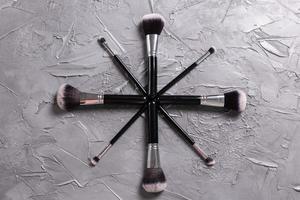 Top view of make-up brushes on grey background photo