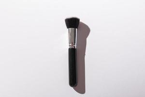 Make-up brush on white background, top view. Cosmetics and beauty concept. photo