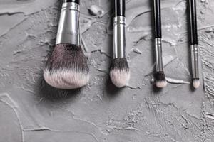 Top view of make-up brushes on grey background with copyspace photo