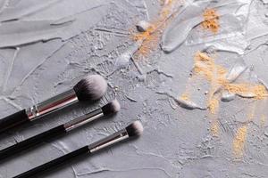 Mineral powder for face and a brushes for powder and visage on grey background. Eco friendly and organic cosmetics. photo