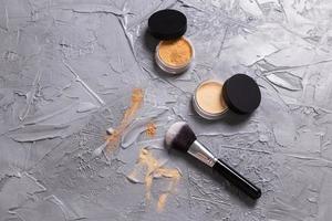 polvo mineral de diferentes colores con pinceles para maquillaje sobre fondo de madera, espacio de copia foto