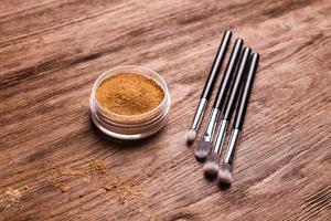 base de polvo mineral con pinceles sobre un fondo de madera. productos de belleza ecológicos y orgánicos foto