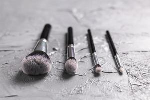 Top view of make-up brushes on grey background photo