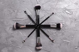 Top view of make-up brushes on grey background photo