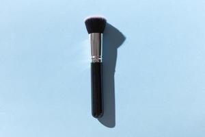 Make up brush on blue background, top view. photo